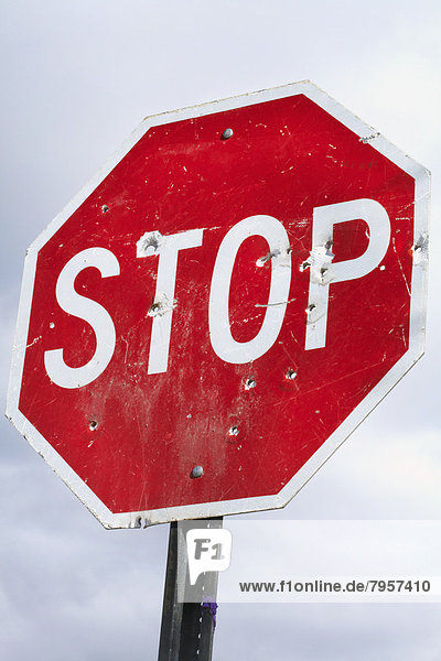 Low angle view of stop sign with bullet holes