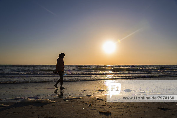 USA  Florida  Indian Rocks Beach  Reife Frau am Strand bei Sonnenuntergang