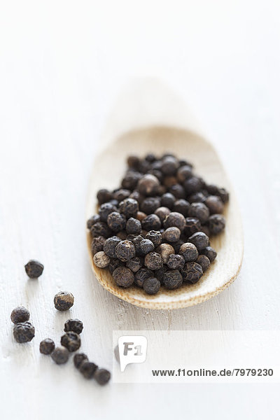 Black peppercorn on wooden spoon  close up