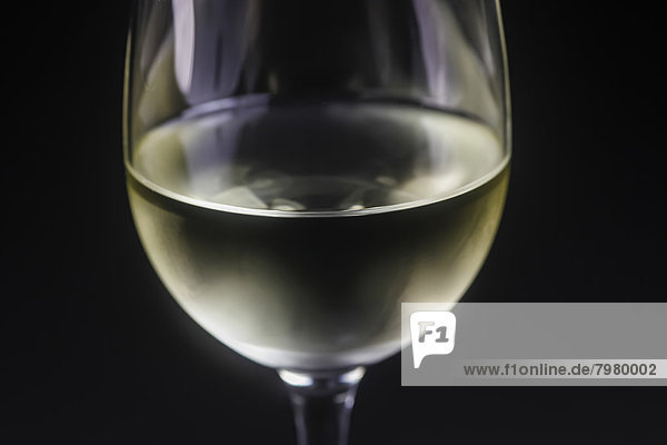 Glas Weißwein auf schwarzem Hintergrund  Nahaufnahme
