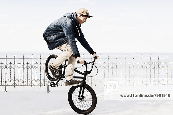 Germany  Schleswig Holstein  Teenage boy jumping with BMX bike