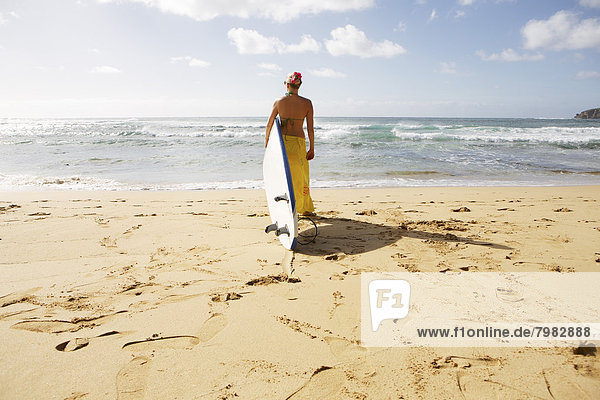 USA  Hawaii  Mittlere erwachsene Frau stehend mit Surfbrett am Strand