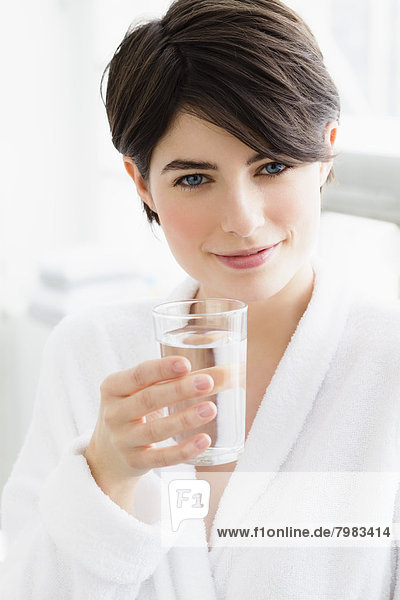 Portrait of young woman holding water glass  close up
