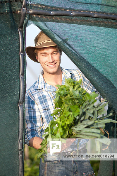 Junger Mann mit Gemüse vom Bauernhof