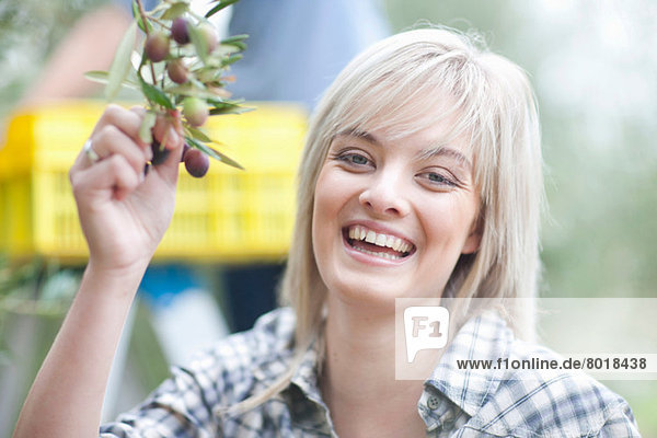 Woman holding olives in olive grove portrait