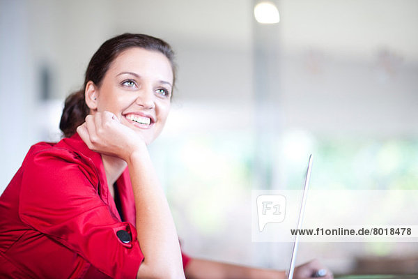 Young woman with hand on chin looking away