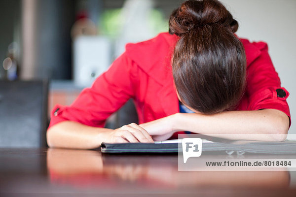 Young woman with head on desk