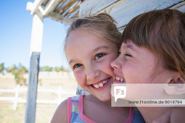 Smiling Between Two Cheeks Portrait of two girls cheek to cheek smiling