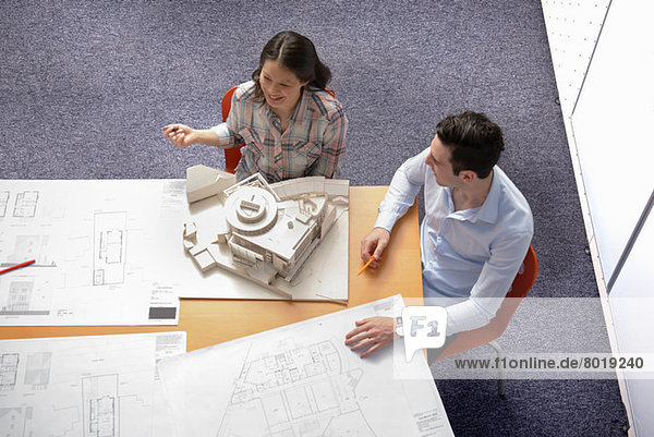 Zwei Architekten diskutieren Pläne und Modellbau im Besprechungsraum