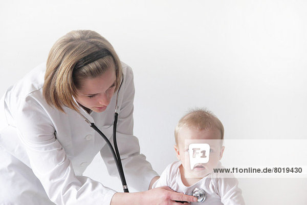 Ärztin untersucht die Brust des Babys
