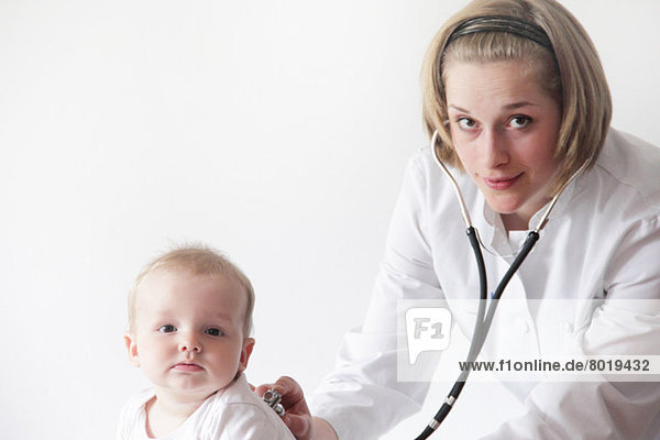 Female doctor examining baby's breathing