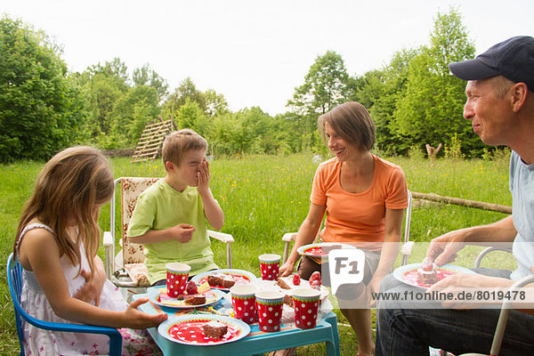 Familie mit zwei Kindern beim Geburtstagspicknick