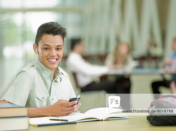 Young student wearing earphones and holding mp3 player  portrait
