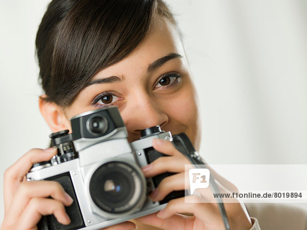 Young woman holding camera  portrait