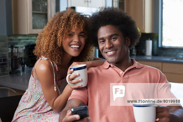 Mid adult woman and mature man holding coffee mugs portrait