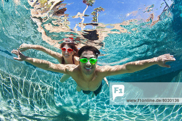 Junges Paar schwimmt unter Wasser im Pool