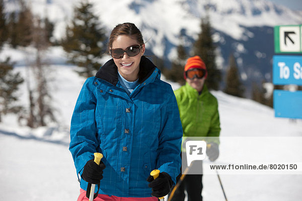 Junge Frau in Skibekleidung mit Skistöcken  Portrait