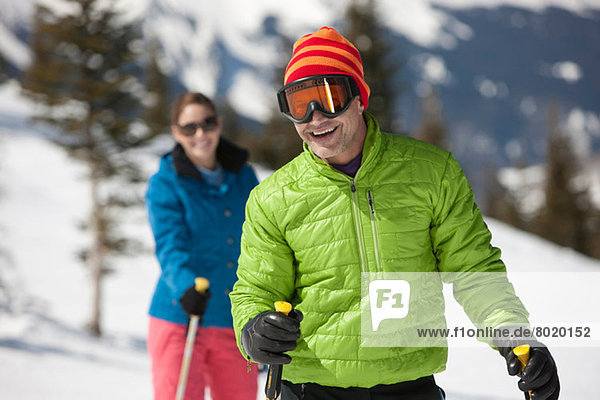 Erwachsener Mann in Skibekleidung mit Skistöcken  Portrait