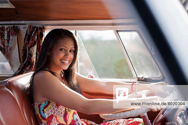 Junge Frau fährt Wohnmobil und lächelt  Portrait