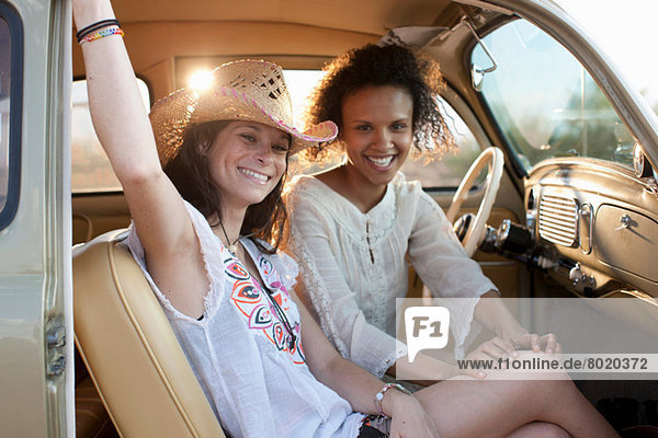 Junge Frauen sitzen im Auto auf Roadtrip  Porträt