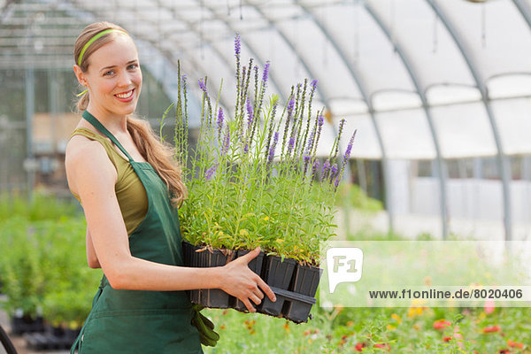 Mittlere erwachsene Frau mit Pflanzen im Gartencenter  Portrait