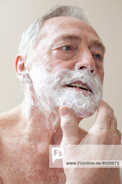 Senior Mann beim Auftragen von Rasiercreme