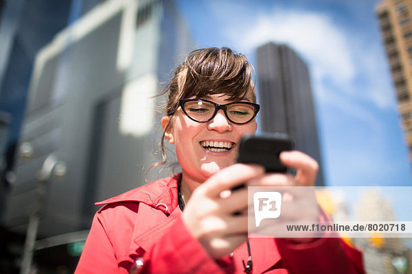 Portrait of woman in city looking at smartphone