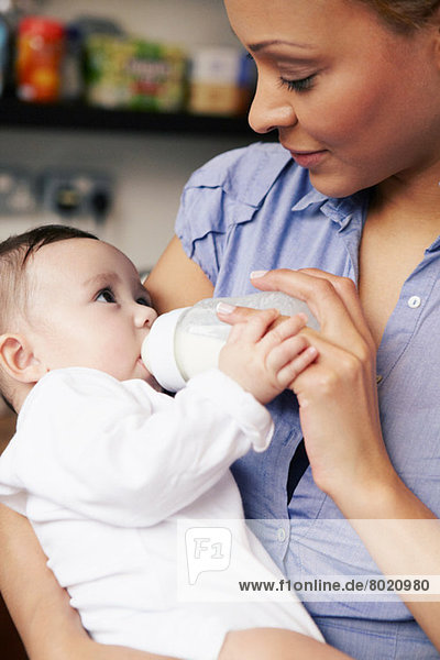 Mutter füttert Babymädchen Flasche Milch