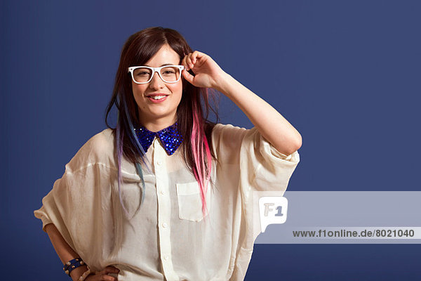 Porträt einer jungen Frau mit gefärbtem Haar und Brille