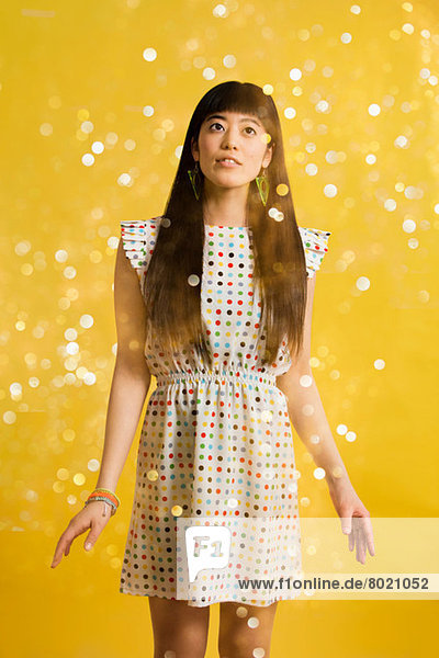 Portrait of young woman wearing spotted dress with glitter
