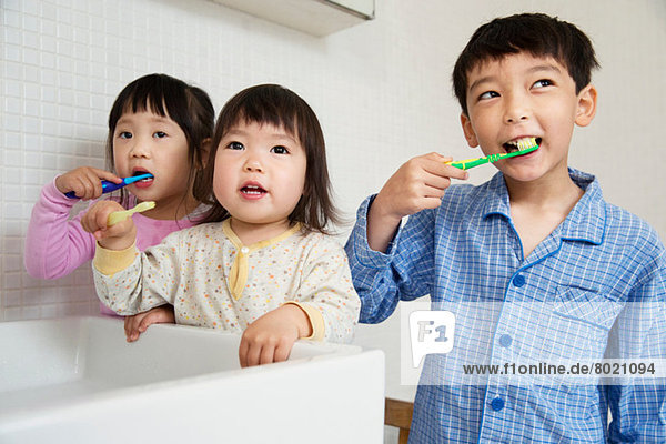 Brother and sisters cleaning teeth