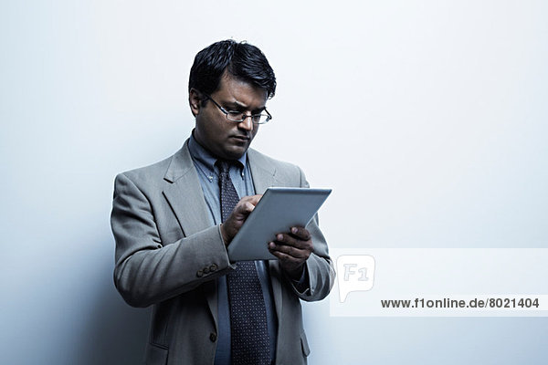 Studio-Porträt eines Geschäftsmannes mit digitalem Tablett