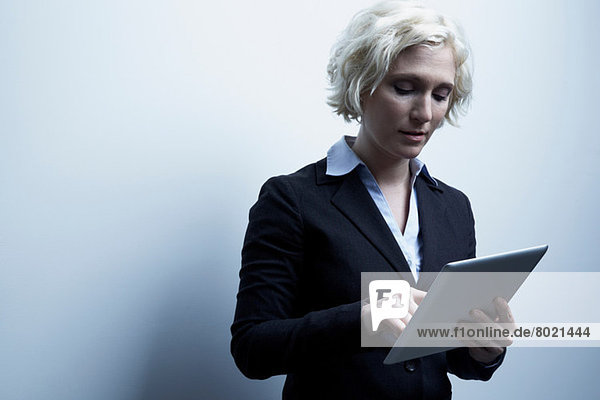 Studio-Porträt einer blonden Geschäftsfrau mit digitalem Tablett