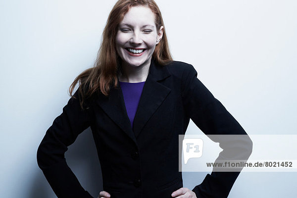 Studio-Porträt einer jungen Geschäftsfrau lächelnd