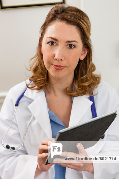 Mid adult doctor using digital tablet  portrait