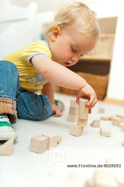 A boy is playing with building bricks.