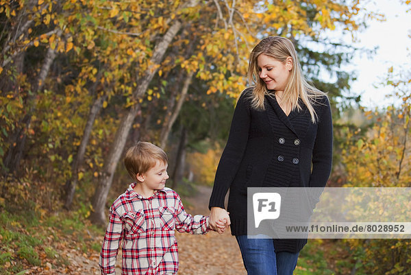 Mother and son walking on a path in a park in autumn Edmonton alberta canada