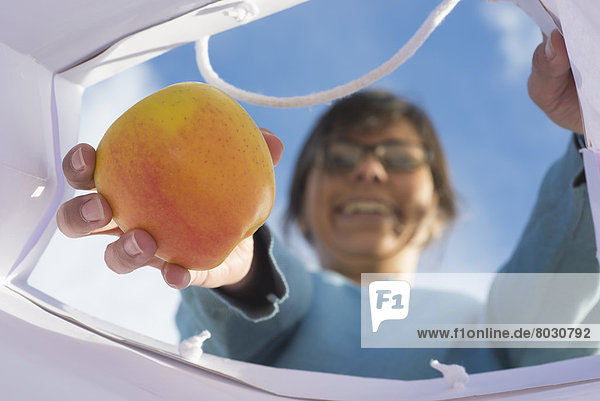 A woman pulling a piece of fruit from a shopping bag Locarno ticino switzerland