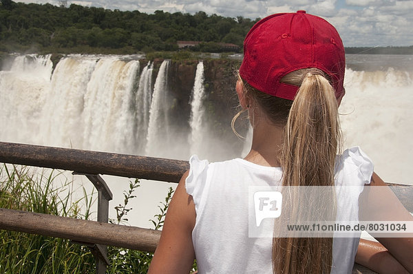 Girl watching iguazu falls from outlook point Argentina