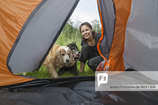 A woman and her two dogs look into the doorway of a tent Locarno ticino switzerland