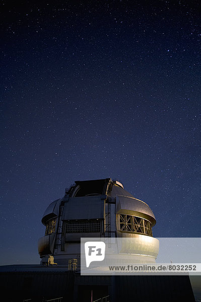 Hawaii  Big Island  Mauna Kea summit  Gemini Observatory  Milky Way and starry sky above  Low light exposure.