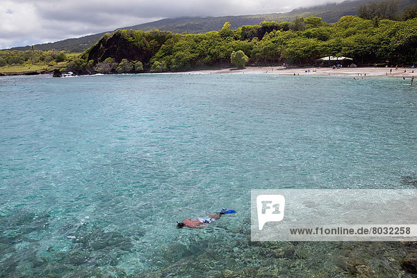 Hawaii  Maui  Hana  A man snorkels among clear water in Hana.