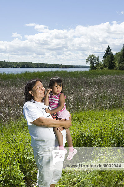 stehend  nebeneinander  neben  Seite an Seite  Fischschwarm  See  Enkeltochter  Großmutter  Feld  Ethnisches Erscheinungsbild  Kanada  Ontario