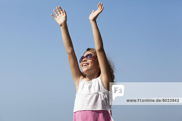 Young smiling girl in sunglasses reaching for the clear blue sky Whitby ontario canada