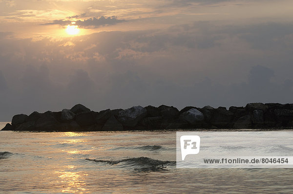 Sunrise on Adriatic sea with rocks and clouds  Porto San Giorgio  Marche  Italy