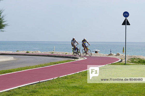 Men cycling on bicycle lane with view of sea  Lido Tre Archi  Marche  Italy
