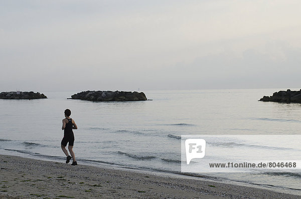 Jogger running on beach at sunrise  Porto San Giorgio  Marche  Italy
