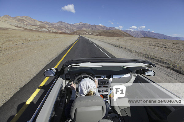 USA  California  Young woman driving convertible car  Death Valley National Park