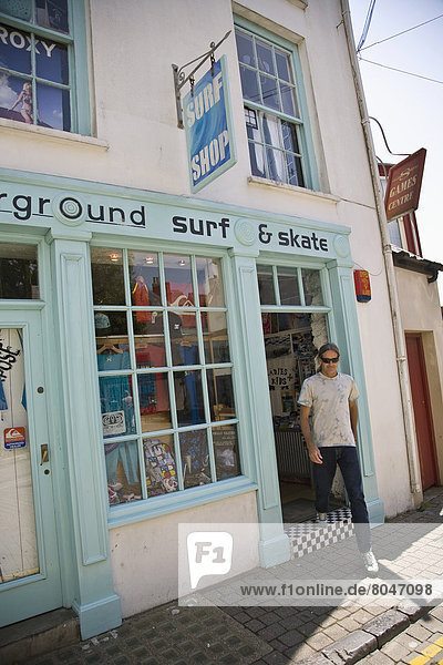 United Kingdom  Wales  Pembrokeshire  Man leaving surf shop  Saundersfoot