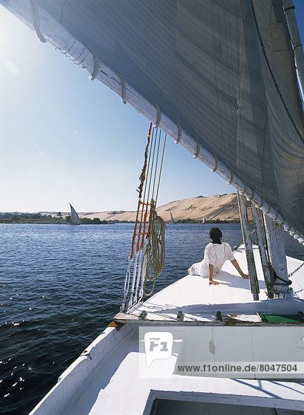 Woman sitting on bow of felucca on River Nile  Aswan  Egypt